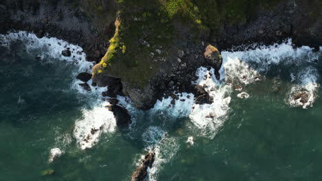 waves breaking on the rugged coastline of south cornwall, england seen from a drone point of view
