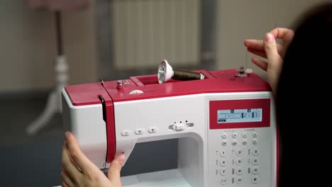 un carrete para hilos está instalado en un dispositivo de enrollamiento de bobina en una máquina de coser. instalación. accesorios. preparación para coser