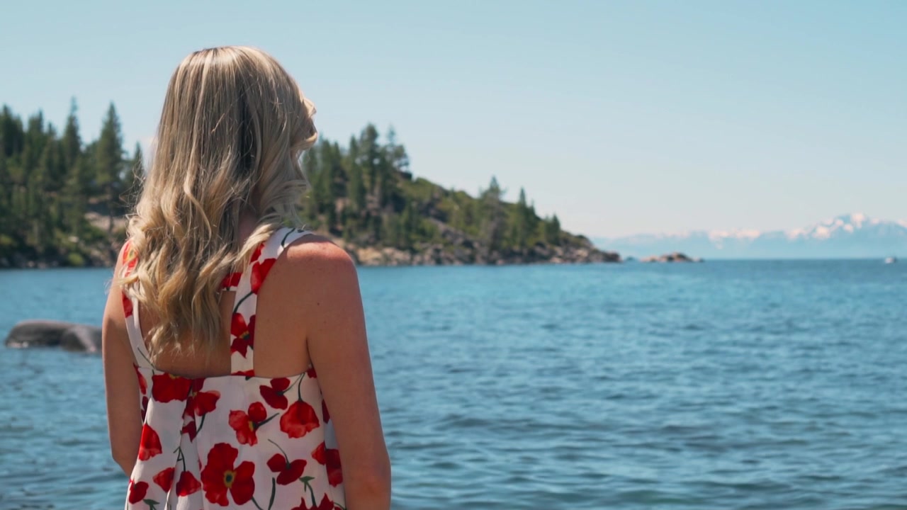 Woman with Long Blonde Hair Looking at a Scenic Lake View
