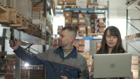 employee takes inventory using scanner of large distribution center