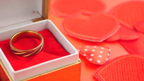 gold ring in a gift box with hearts