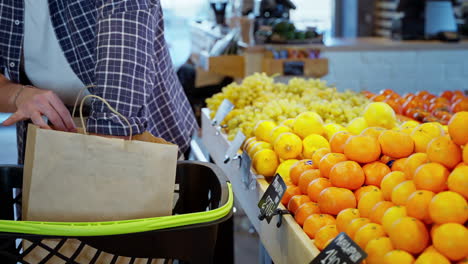 hombre comprando mandarinas en una tienda de comestibles
