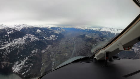 Airplane-cockpit-view-of-landing-approach-through-Sion-Valley-mountains