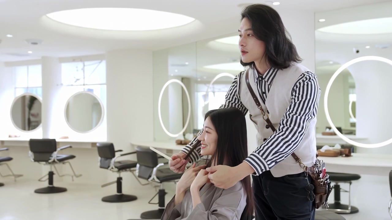 Giovane cliente donna che riceve un taglio di capelli alla moda da un parrucchiere stilista, si consulta e chiacchiera con la cliente per il servizio, la cura o la pettinatura prima dell'appuntamento dal parrucchiere in un salone boutique