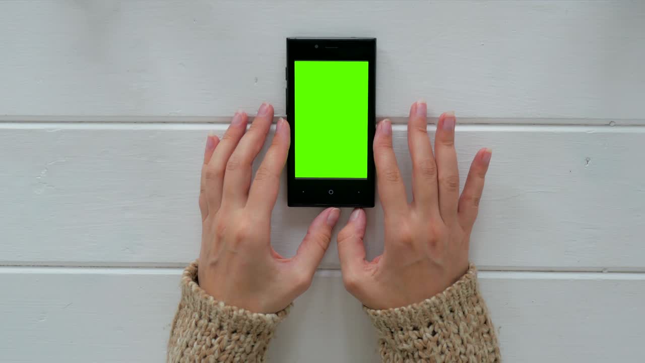 Donna che guarda lo smartphone con schermo verde