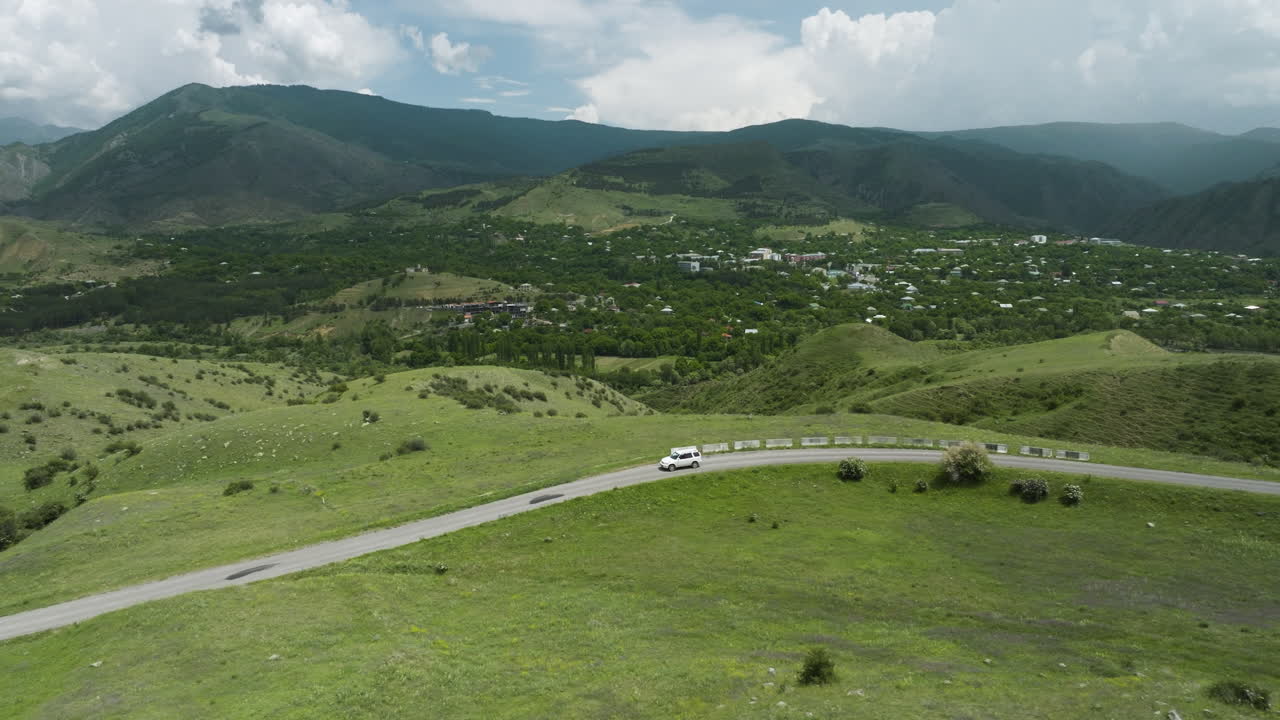 coche conduciendo por una carretera larga y sinuosa que pasa a través de exuberantes colinas verdes fuera de aspindza en georgia