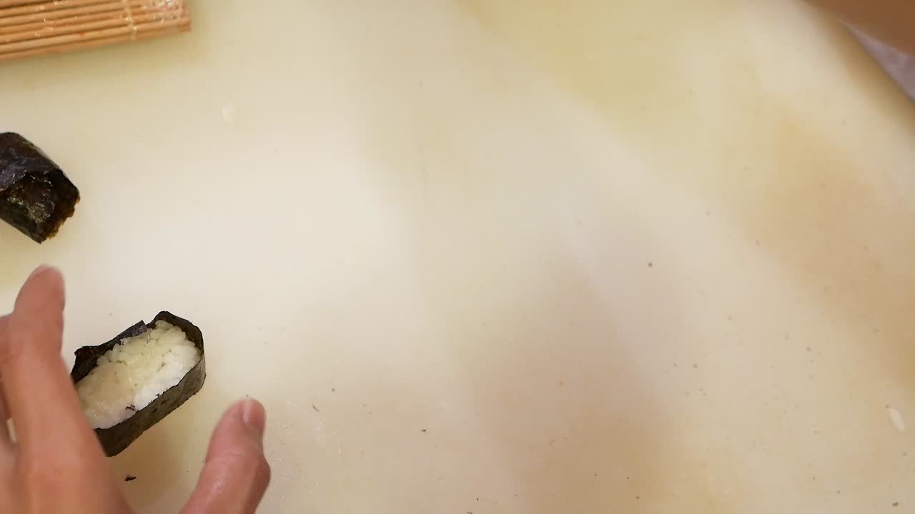 마른 해초로 일본 쌀 랩을 손으로 눌러 초밥을 만들고 닫습니다.