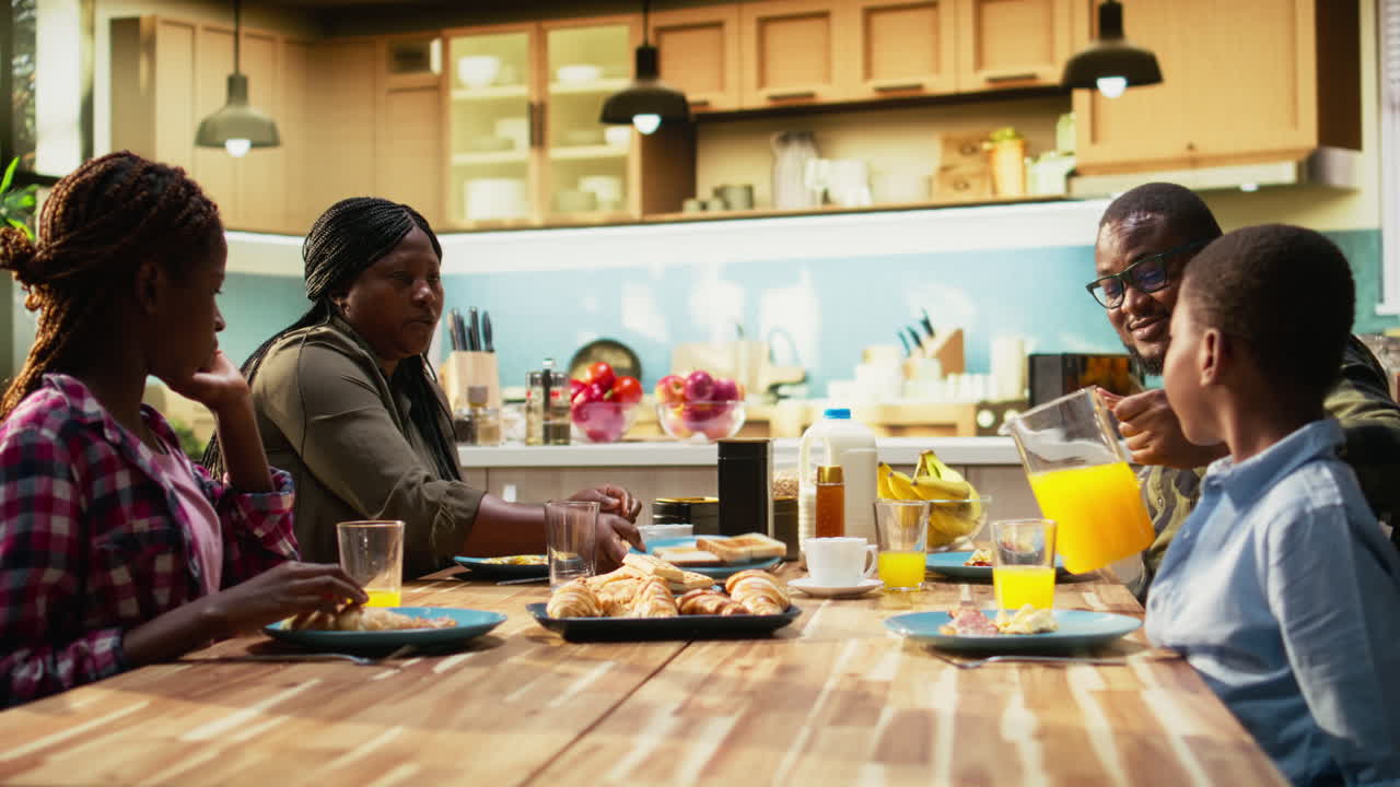 African American family enjoying breakfast together at the dining table