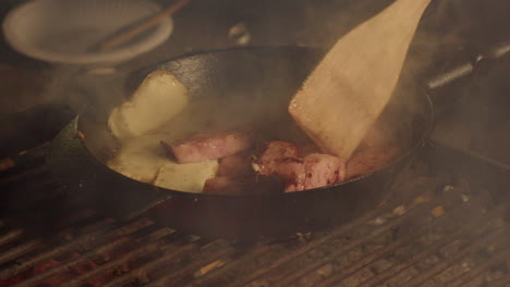 Holzspatel-Dreht-Schinkenscheiben-Und-Halloumi-Käse-Auf-Offenem-Feuer