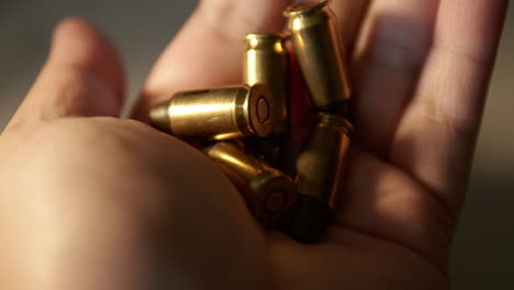 close up of a hand holding a number of bullets