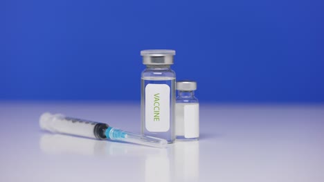 coronavirus vaccine bottles on background laboratory table. syringe close up for covid-19. concept defeating coronavirus. blue screen, chroma key. close up. slow motion