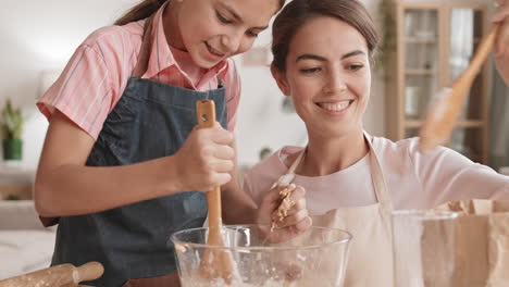 mom and teenage daughter making dough together
