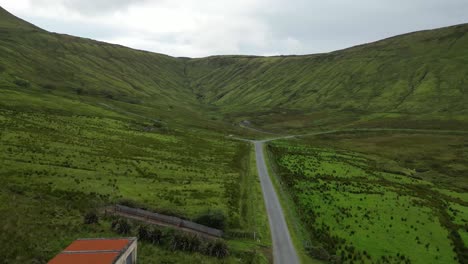 Drohnenaufnahme-Eines-Glenniff-Hufeisens,-Das-Rückwärts-Die-Straße-Entlangfliegt