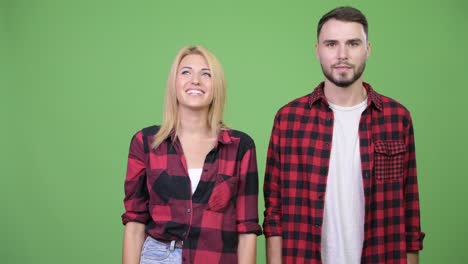 young happy couple showing something together