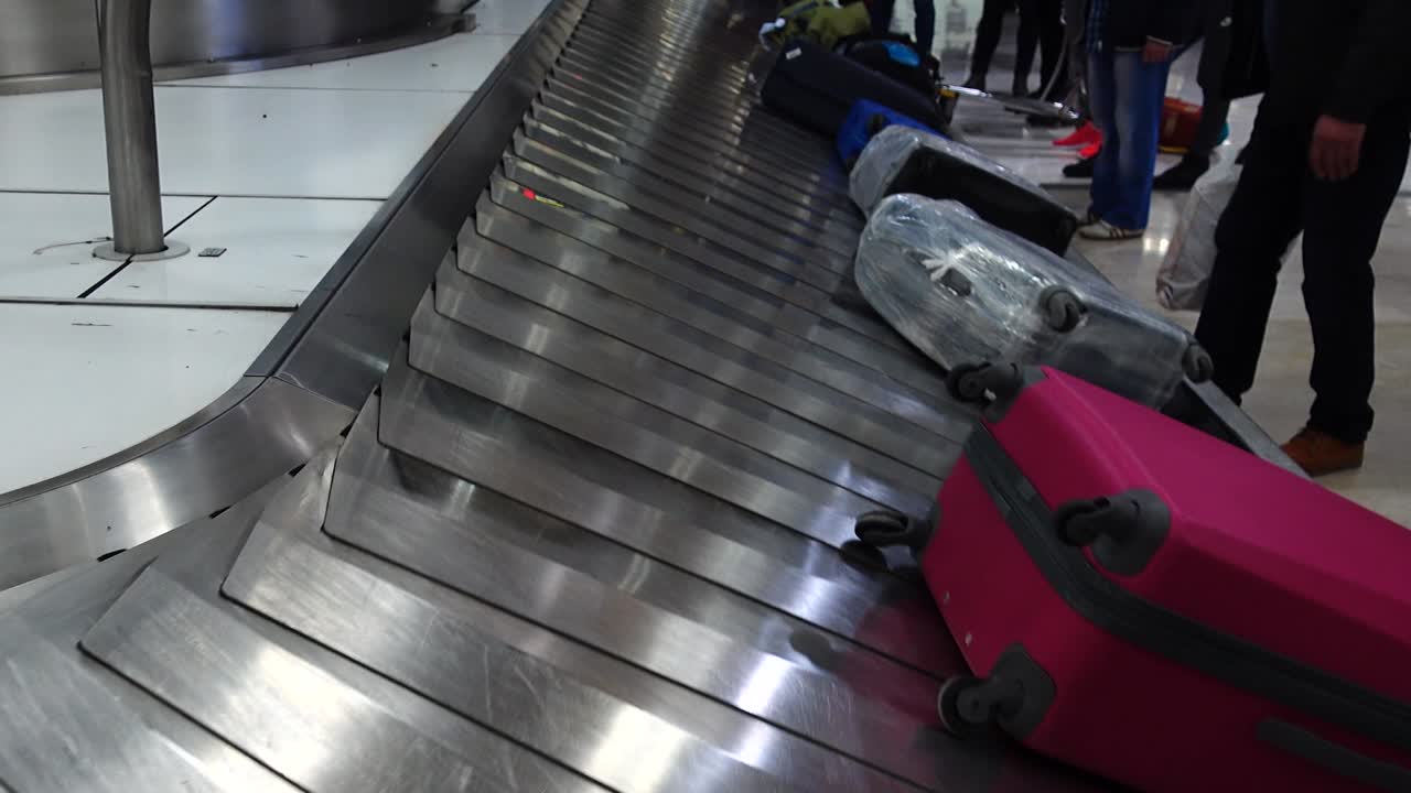 Bagageudlevering i lufthavnen. Passagerer venter på deres bagage efter ankomst