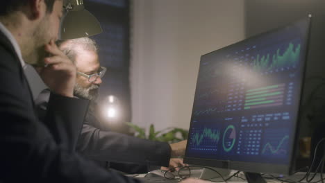 two male colleagues working together in office late