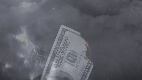 digital composition of burning american dollar bill against thunderstorm in night sky