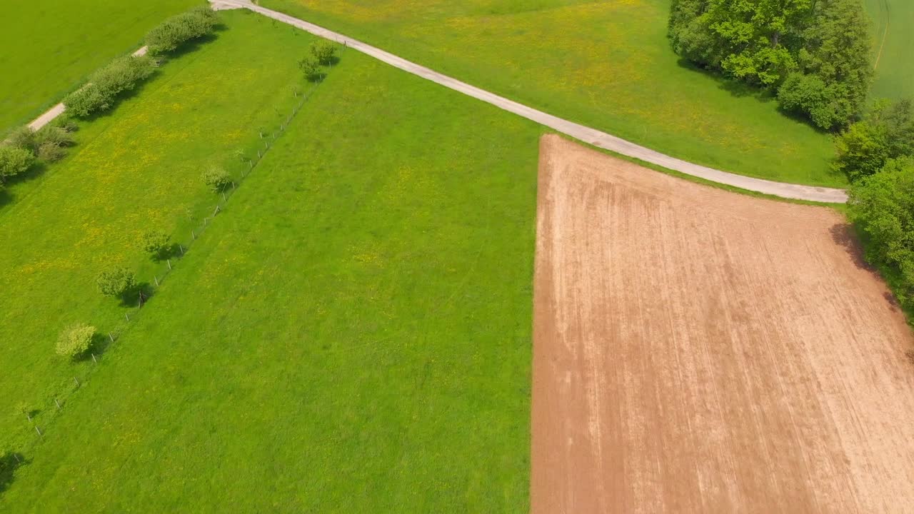 flying over rolling hills with fields in a rural countryside