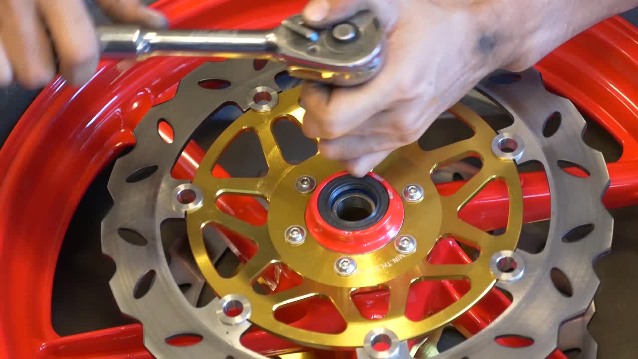 imágenes de primer plano de un mecánico que trabaja en la instalación de frenos de disco para motocicletas