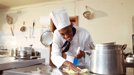 chef limpiando la superficie de trabajo en la cocina comercial