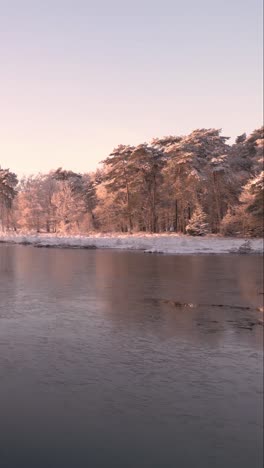 winter landscape with frozen river and snow-covered trees