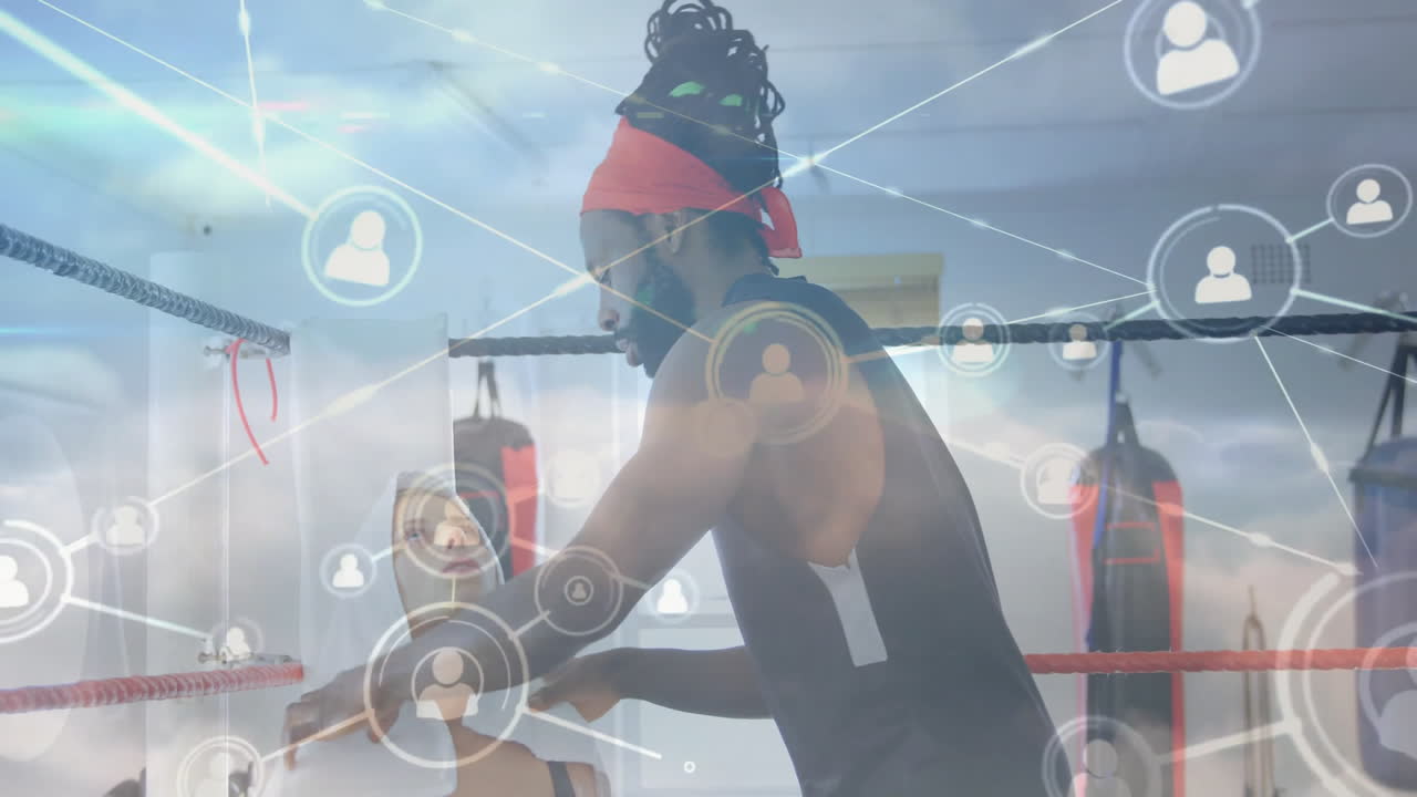 male trainer wrapping boxer's hands in fitness boxing gym, with digital network icons floating