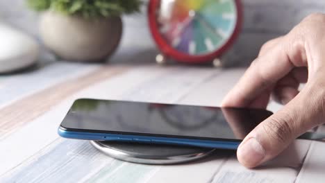 hand placing smartphone on wireless charging pad