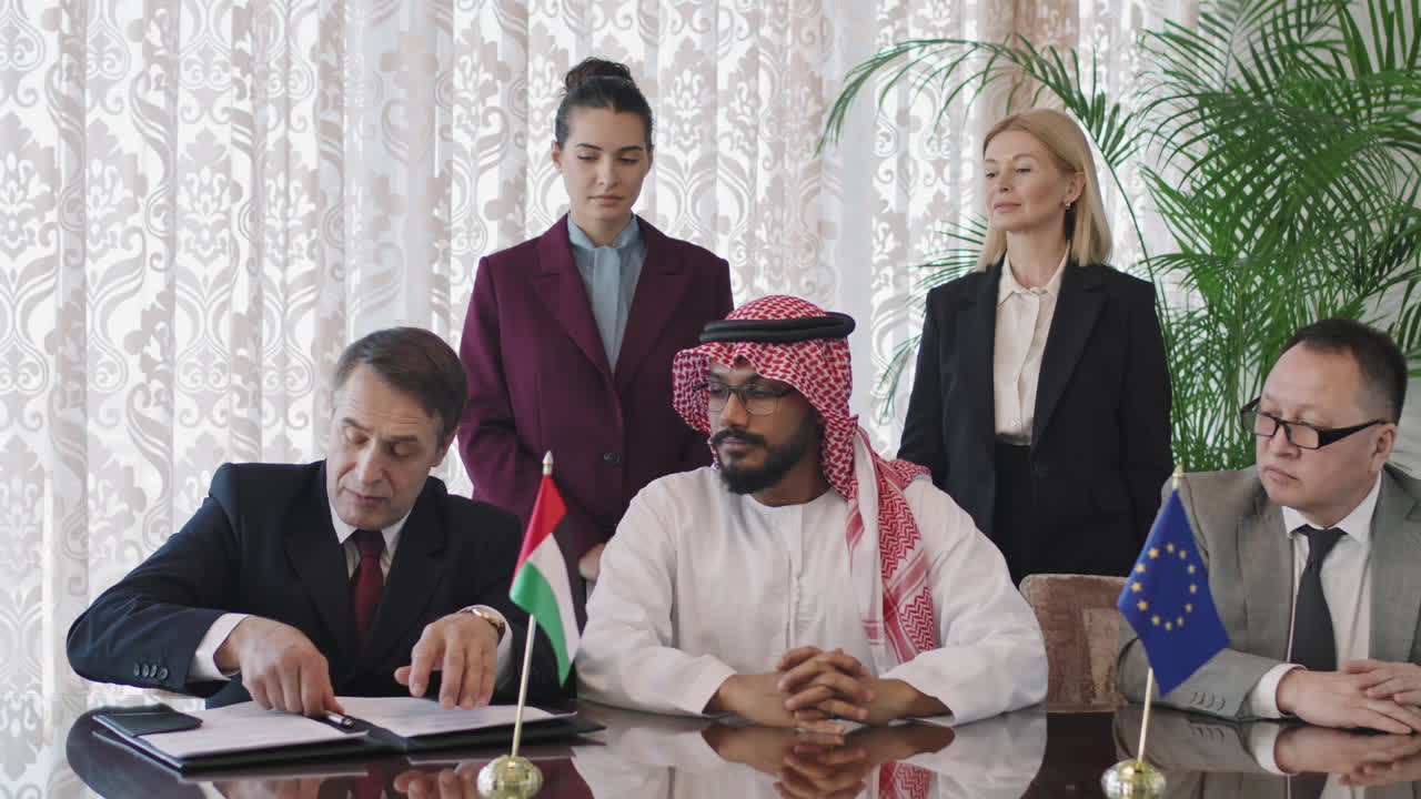 다양한 투자자들이 협상 테이블에서 계약서에 서명합니다.