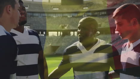 Animation-of-flag-of-belgium-over-diverse-male-rugby-players-talking-at-stadium