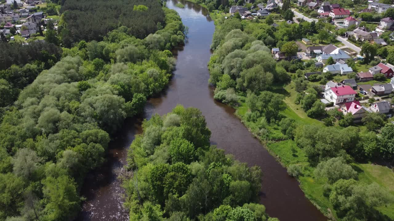 Opstigende luftoptagelse med overflyvning over floden i den lille by Ukmerge i Litauen