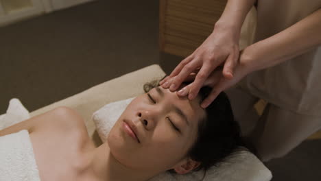 close-up of a person receiving a relaxing head massage at a spa