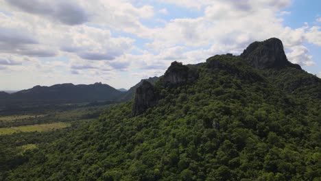 aerial view of lush mountain range with cliffs and forest