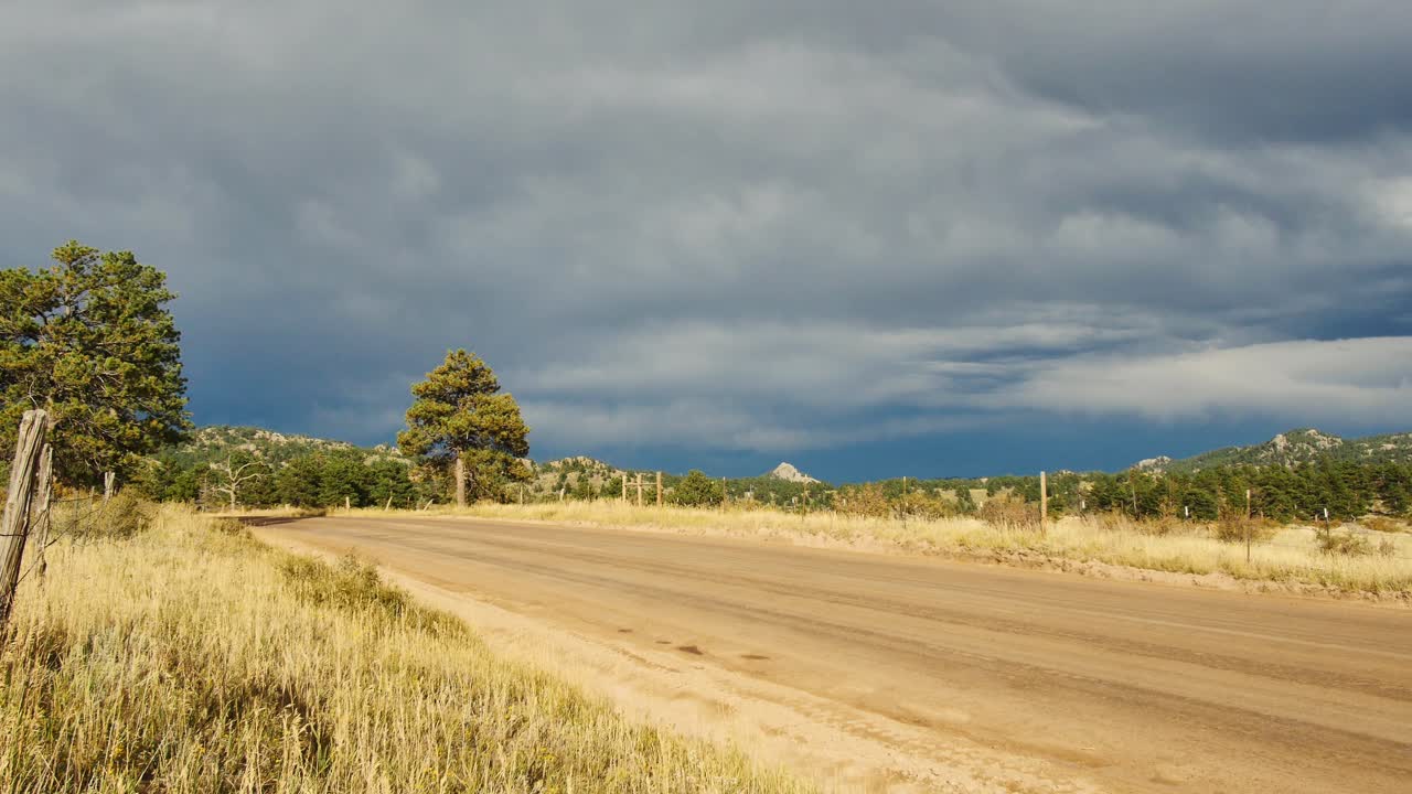 Uma estrada de terra no interior do Colorado enquanto nuvens de tempestade começam a se formar.