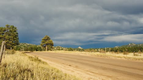 a dirt road in the colorado countryside as storm clouds start to roll in