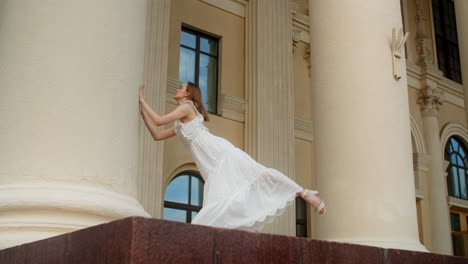 ballet dancer stretching in front of a building