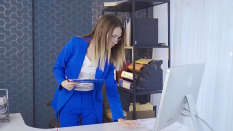 joven empresaria creativa usando una computadora portátil en el escritorio de la oficina y tomando notas.