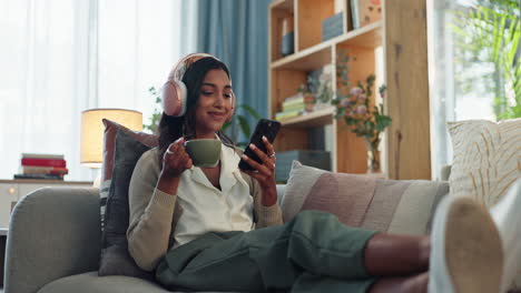 smiling woman relaxing on a couch with headphones