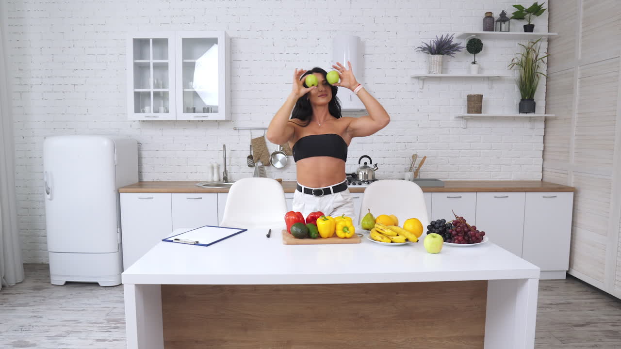 Donna sana in cucina con frutta e verdura.