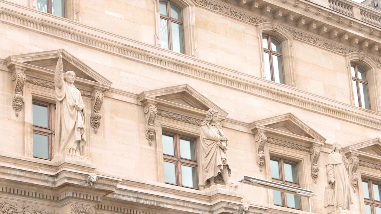 Panorâmica sobre fachada de edifício clássico ornamentado com estátuas.