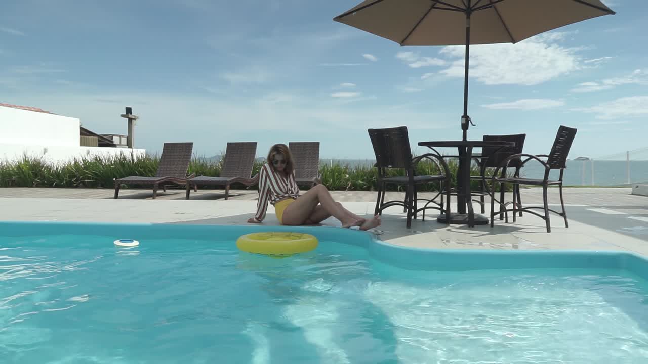 A beautiful Latin girl in a bikini enjoys her summer vacation in the pool of a luxurious hotel in Brazil.