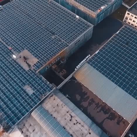 innovative solar station on roofs. photovoltaic cells on a huge solar farm on rooftops of industrial buildings. sustainable source of energy. aerial view.