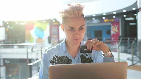 close up hands holding credit card and using laptop indoor, online shopping, woman happy.