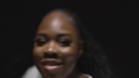 head and shoulders studio portrait shot of young woman dancing with low key lighting against black background 1