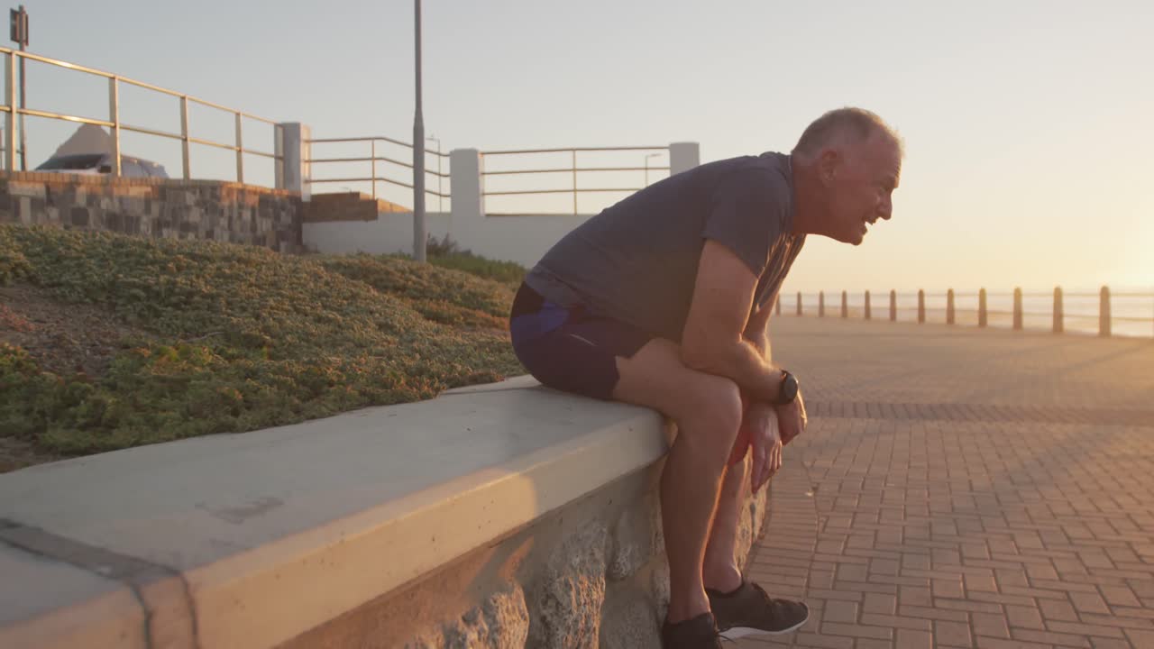 Exhausted senior man sitting on the promenade