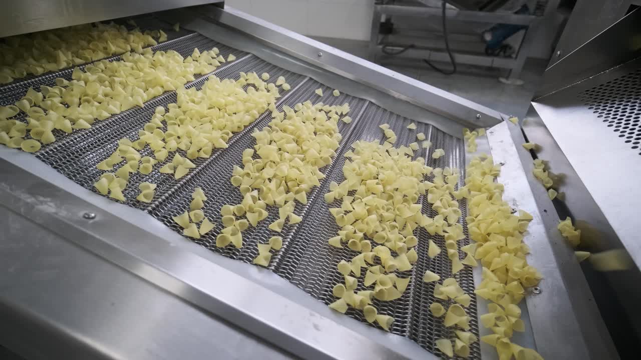 la línea de producción de la fábrica mueve bocadillos de patata. línea de fabricación de la fábrica de pasta, producción de pasta