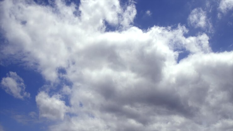 Time Lapse: White fluffy clouds moving across blue sky