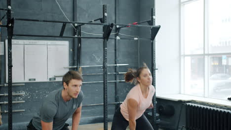 couple working out with kettlebells in gym