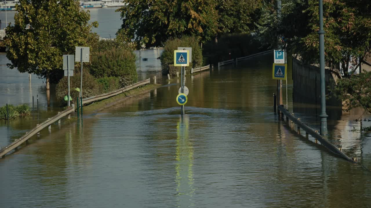 Strada allagata con segnali stradali e alberi sommersi a Budapest, Ungheria, durante l'alluvione del 2024