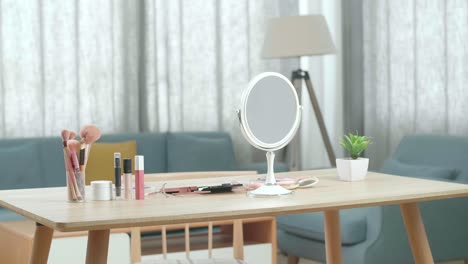 una vanidad con muchos cosméticos y espejo está en una habitación en casa