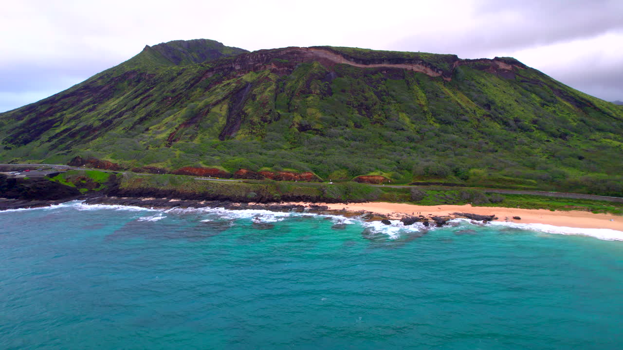 Il Koko Crater si mostra a Oahu, Hawaii, con l'Oceano Pacifico, la spiaggia sabbiosa e il belvedere di Halona Blowhole all'alba.
